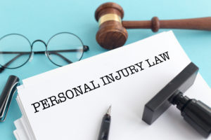 document that says "personal injury law" with pen and glasses and gavel